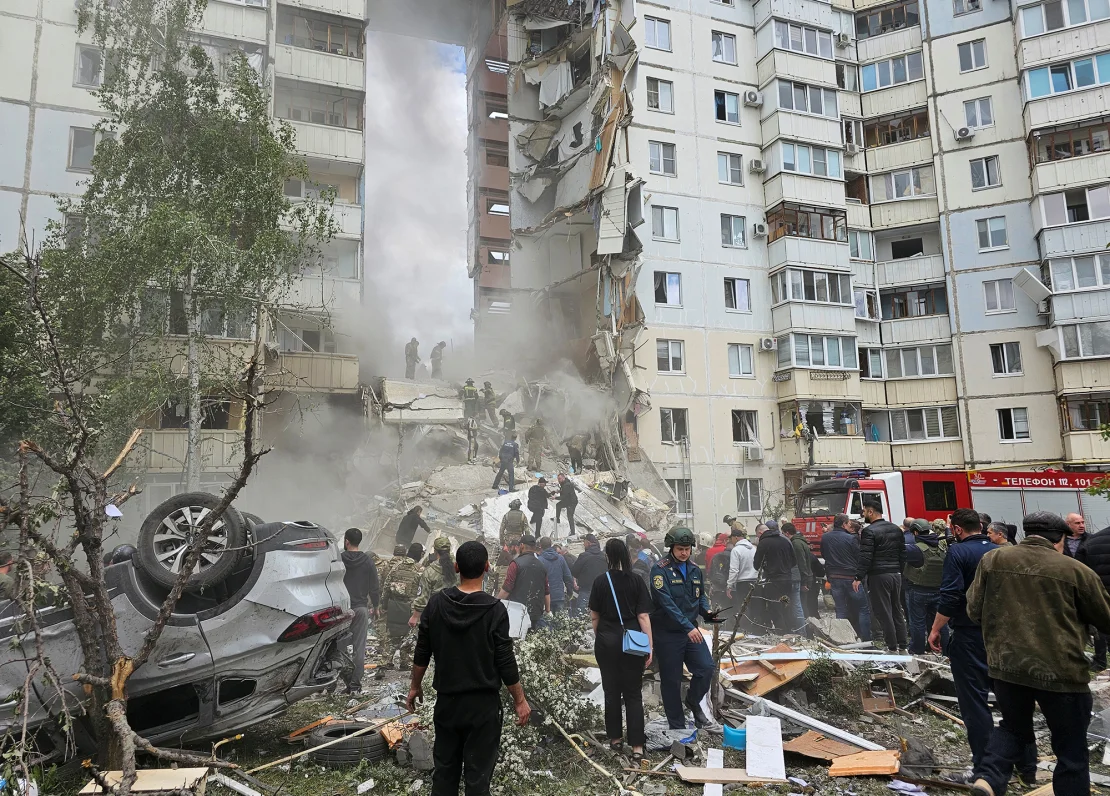 Varias personas se reúnen tras el derrumbe de una sección de un bloque de apartamentos de varios pisos en la ciudad de Belgorod, Rusia, el 12 de mayo de 2024. (Crédito: Reuters)